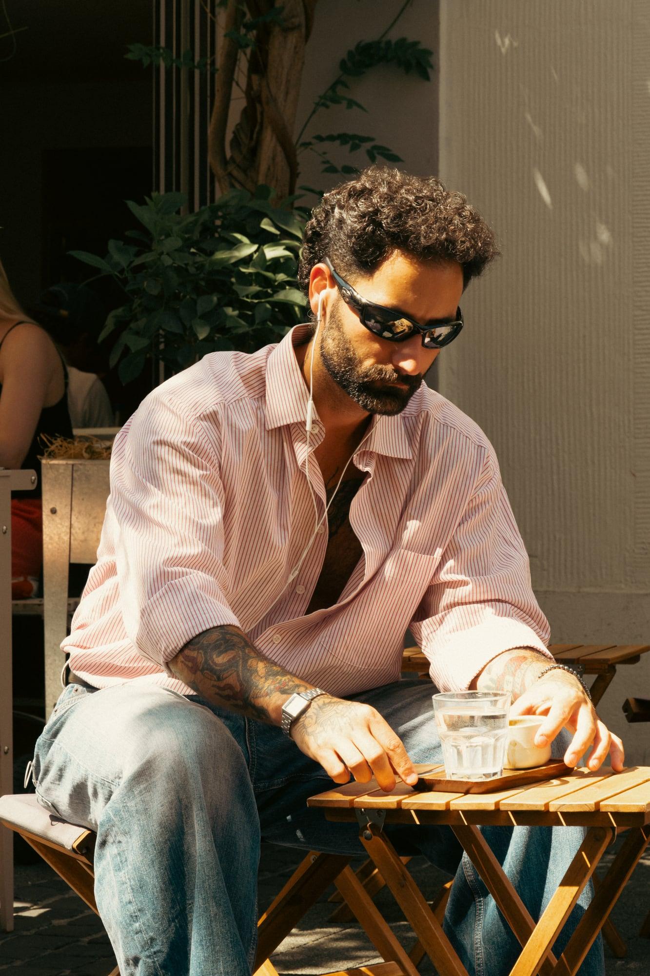 Client avec un café à une table en bois devant HAAFT